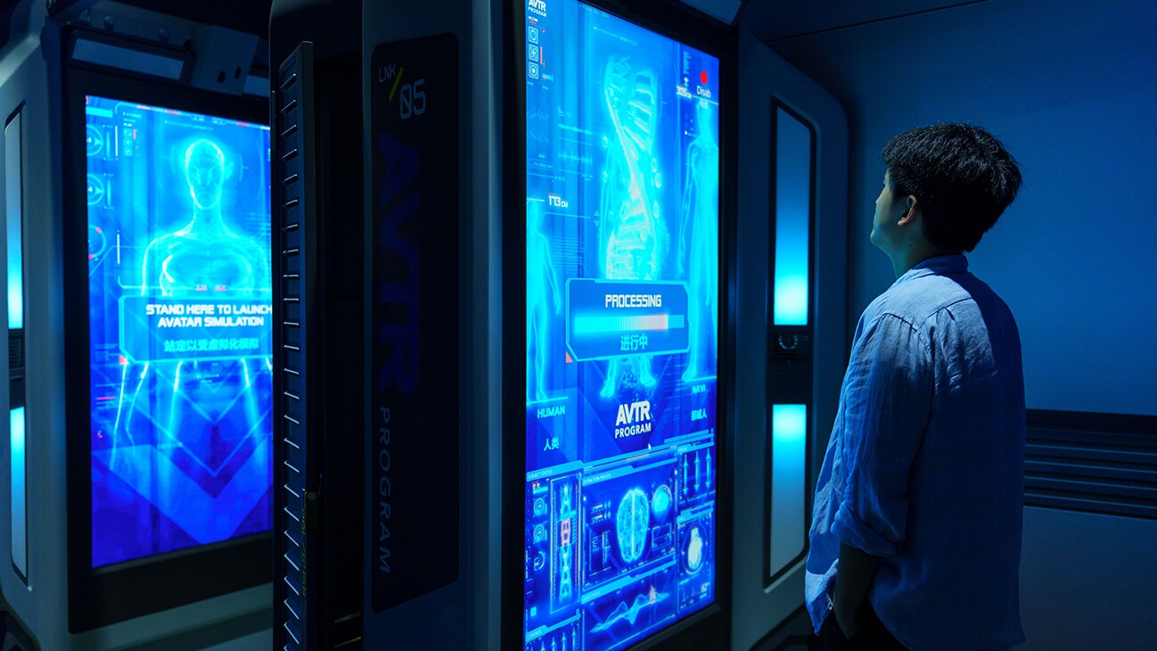 A man stands in front of a screen processing an Avatar Simulation launch.